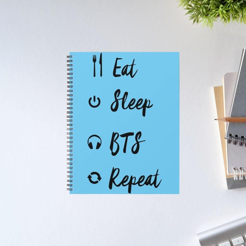 BTS Notebook Eat Sleep Repeat – A5 spiral diary with blue cover featuring Eat Sleep BTS Repeat typography and music icons, perfect K-pop fan stationery gift, Bangtan Boys merch, The Banyan Tee