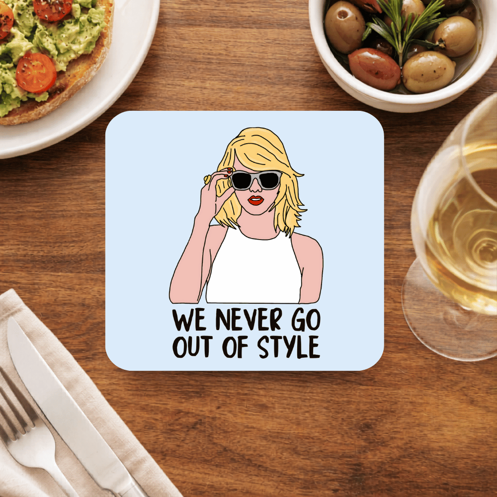 Taylor Swift Style coaster with an illustrated blonde pushing up white sunglasses and the line We never go out of style, on pale blue