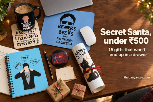 Secret Santa gifts under ₹500: fandom mug, mousepad, notebook, coaster, badge and poster on a desk
