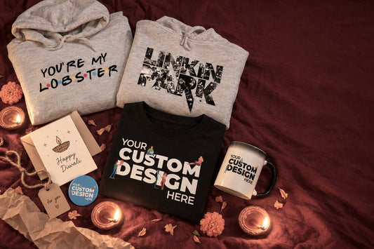 Diwali gifts for boyfriend flatlay with band and sitcom hoodies, a custom T-shirt, mug, badge and card beside lit diyas