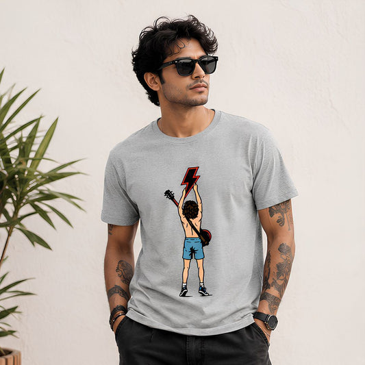Man wearing a gray t-shirt with a graphic design of a person holding a guitar and lightning bolt, standing against a light background. AC/DC t-shirt The Banyan Tee India