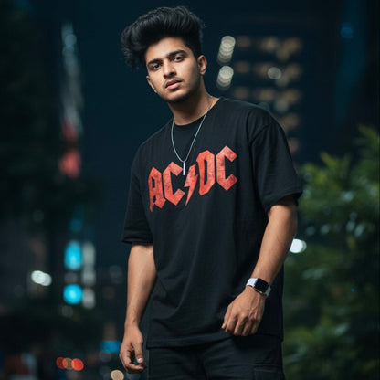 Person wearing an AC/DC t-shirt against a blurred cityscape background The Banyan Tee