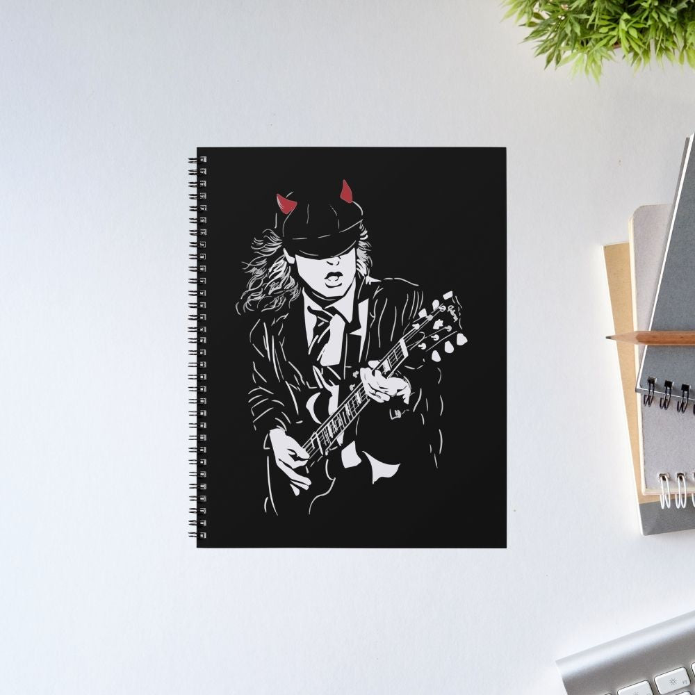 Notebook with a black cover featuring a stylized illustration of a person playing guitar on a white surface. Notebook AC/DC The Banyan Tee