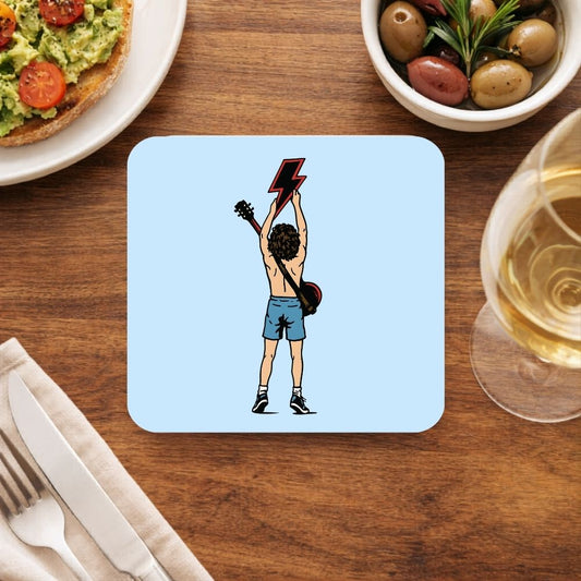 Coaster with a graphic design of a person holding a lightning bolt above their head on a wooden table with food and drink. AC/DC coaster The Banyan Tee
