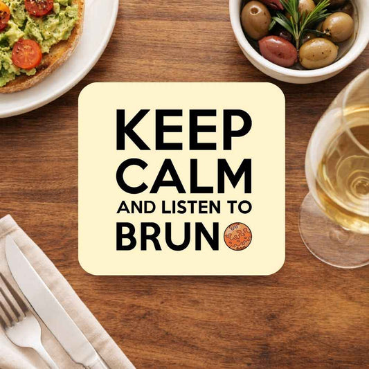 Coaster with 'Keep Calm and Listen to Brun' text on a wooden table with food and wine. Bruno Mars Gift The Banyan Tee India