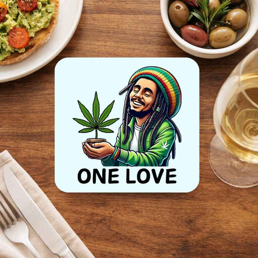 Coaster with a cannabis leaf and 'One Love' text on a table with food and drink. Bob Marley