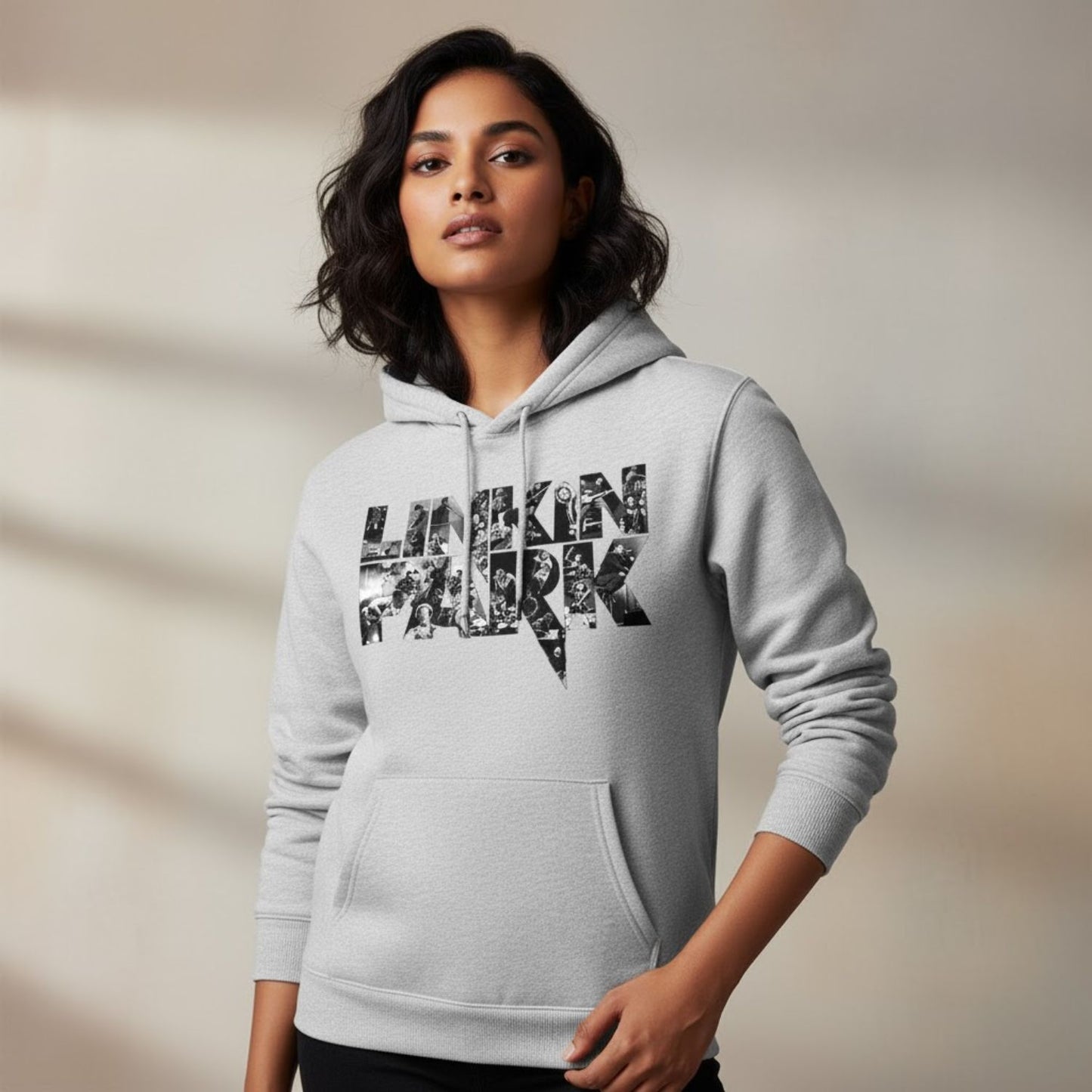 Woman wearing a gray hoodie with 'Linkin Park' text design on a neutral background