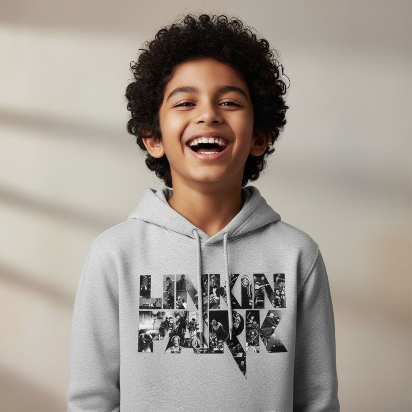 Child wearing a gray hoodie with a collage design on a beige background