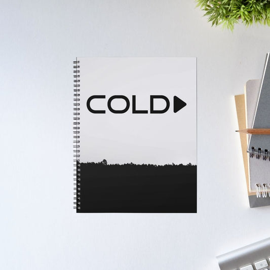 Notebook with 'COLD Play' text on a white surface with office items.  Coldplay The Banyan Tee