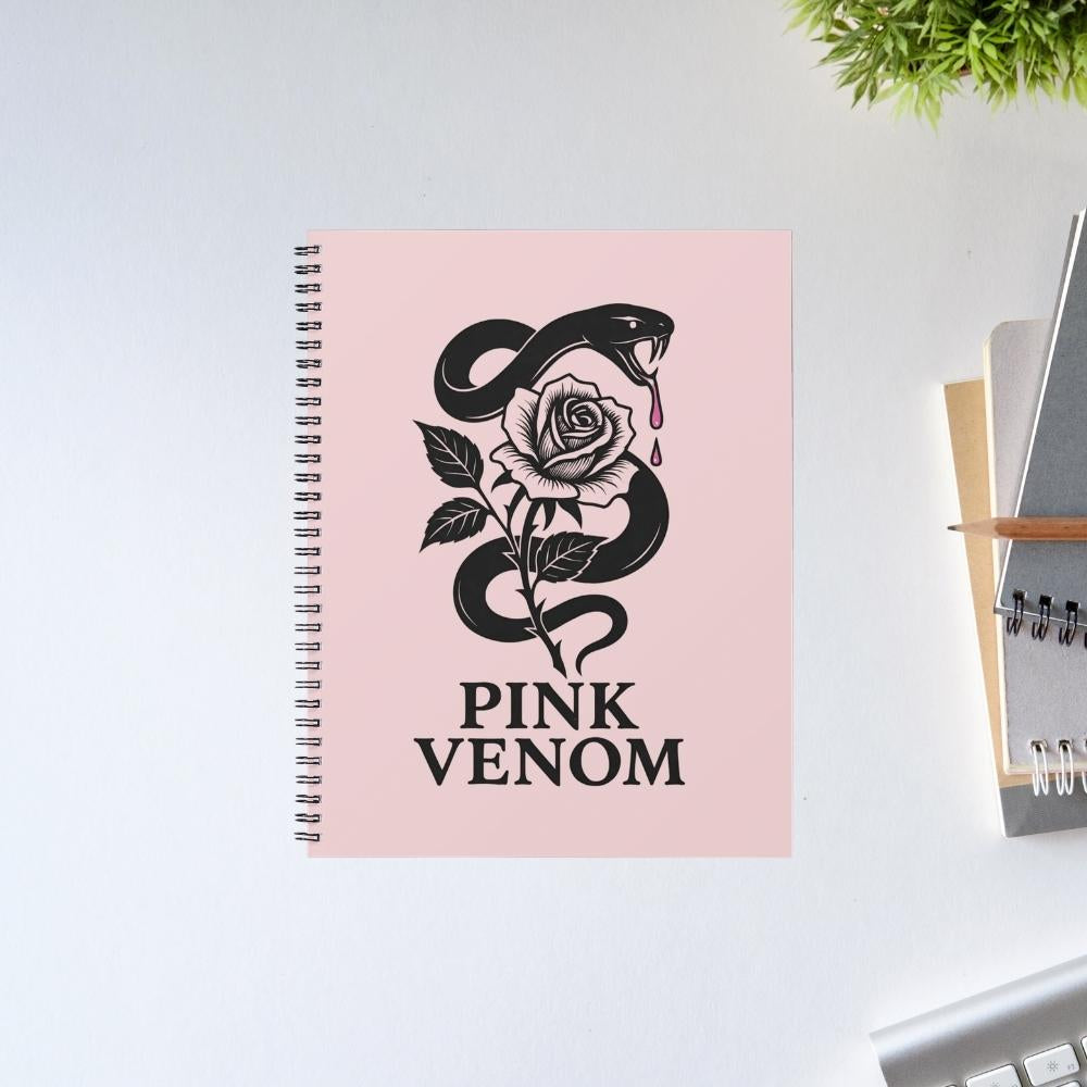 Notebook with 'Pink Venom' design featuring a snake and rose on a pink cover, placed on a light surface. Black Pink Notepad.