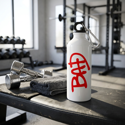 White BAD metal sipper bottle on a gym bench beside dumbbells and a towel