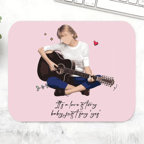 Taylor Swift Love Story mousepad with an illustrated guitarist and the lyric 'It's a love story, baby, just say yes' on a pink mouse pad – non-slip desk mouse mat, The Banyan Tee