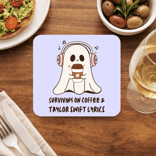 Taylor Swift coaster with a smiling ghost in pink headphones hugging a coffee cup and the line Surviving on Coffee & Taylor Swift Lyrics, on lilac