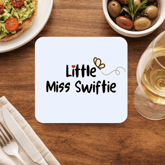 Little Miss Swiftie coaster with playful black lettering, a tiny red heart and a butterfly on a pale blue square